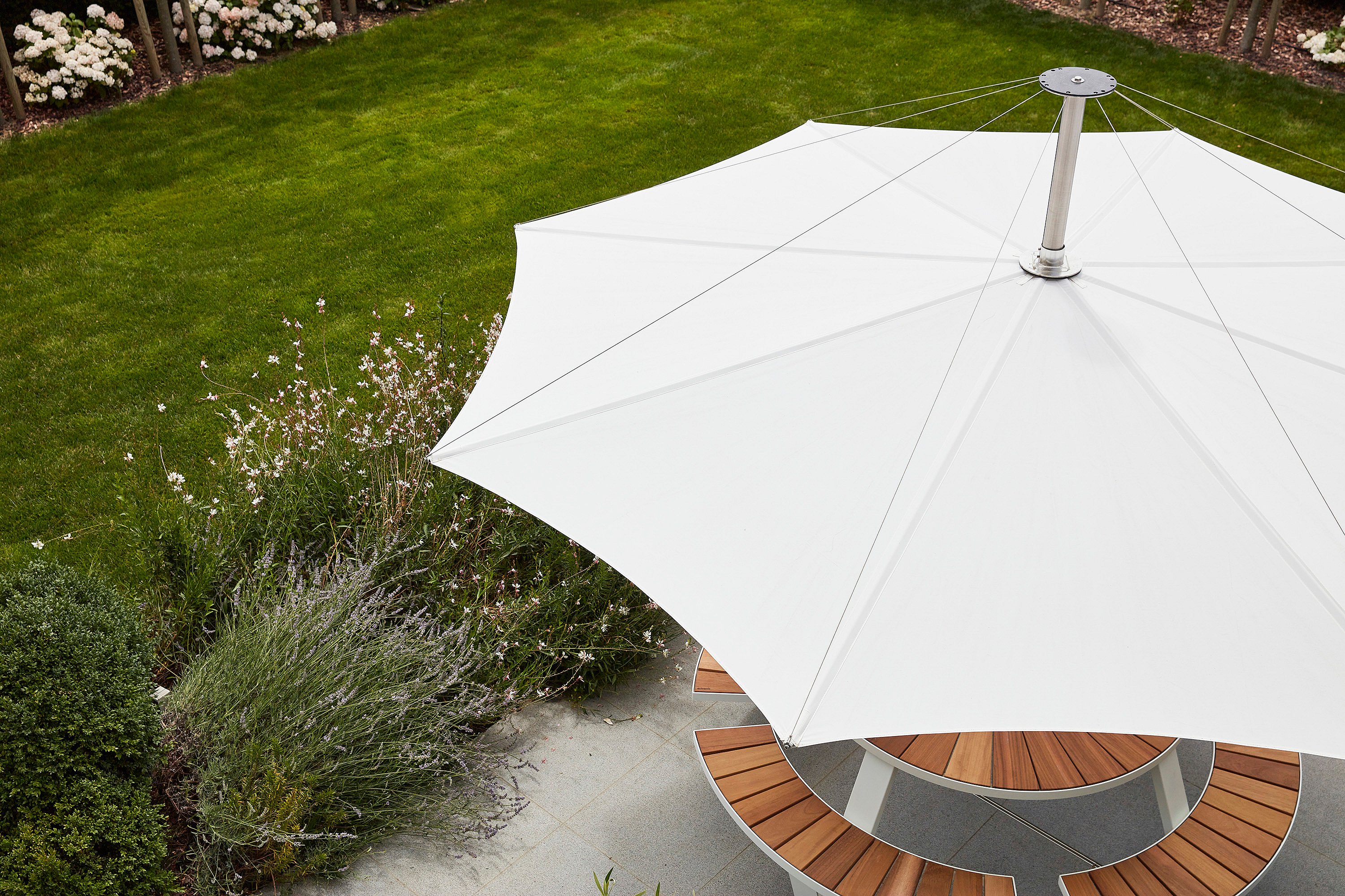   De Inumbra parasol biedt schaduw aan het zitgedeelte van het terras en beschermt iedereen tegen de zon zonder de beenruimte te belemmeren.