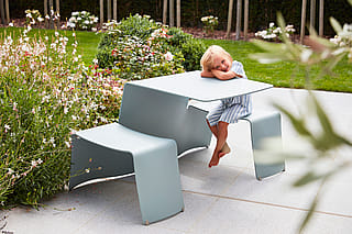 Picknicktafel naast kleurrijke, geurende bloemen, een favoriete plek voor het jongste gezinslid.