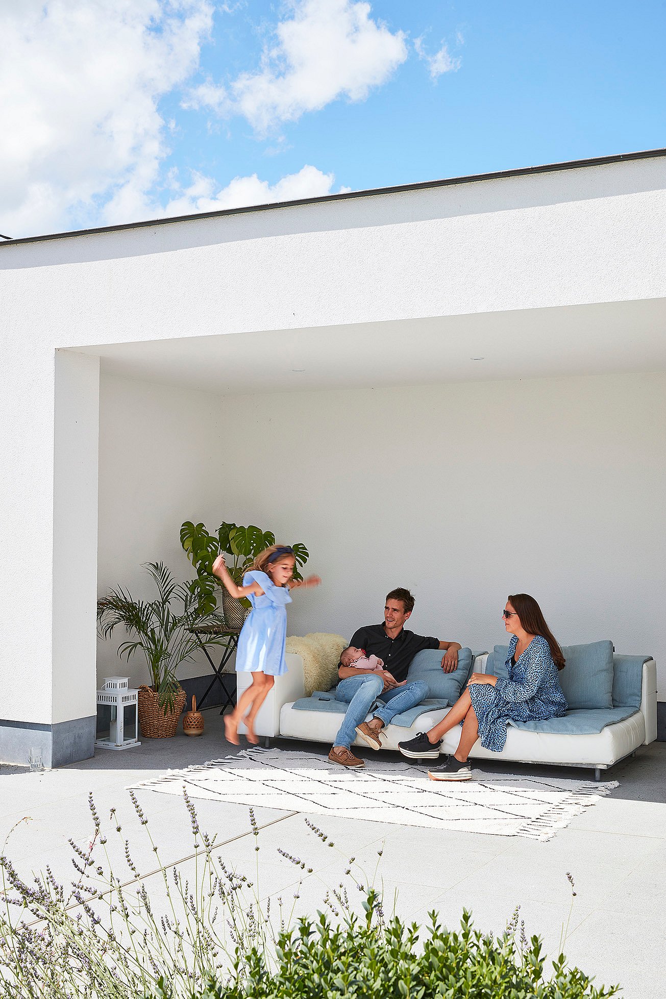   Een hoek die de sofa en de relatie ervan tot de omringende buitenruimte en het groen laat zien.