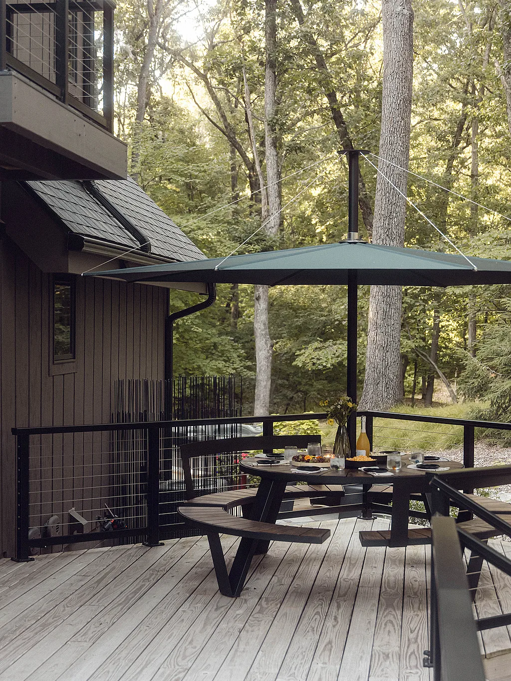 Weitwinkelaufnahme einer Terrasse in Michiana Shores mit mehreren runden Tischen und Bänken auf einem hellen Holzdeck.