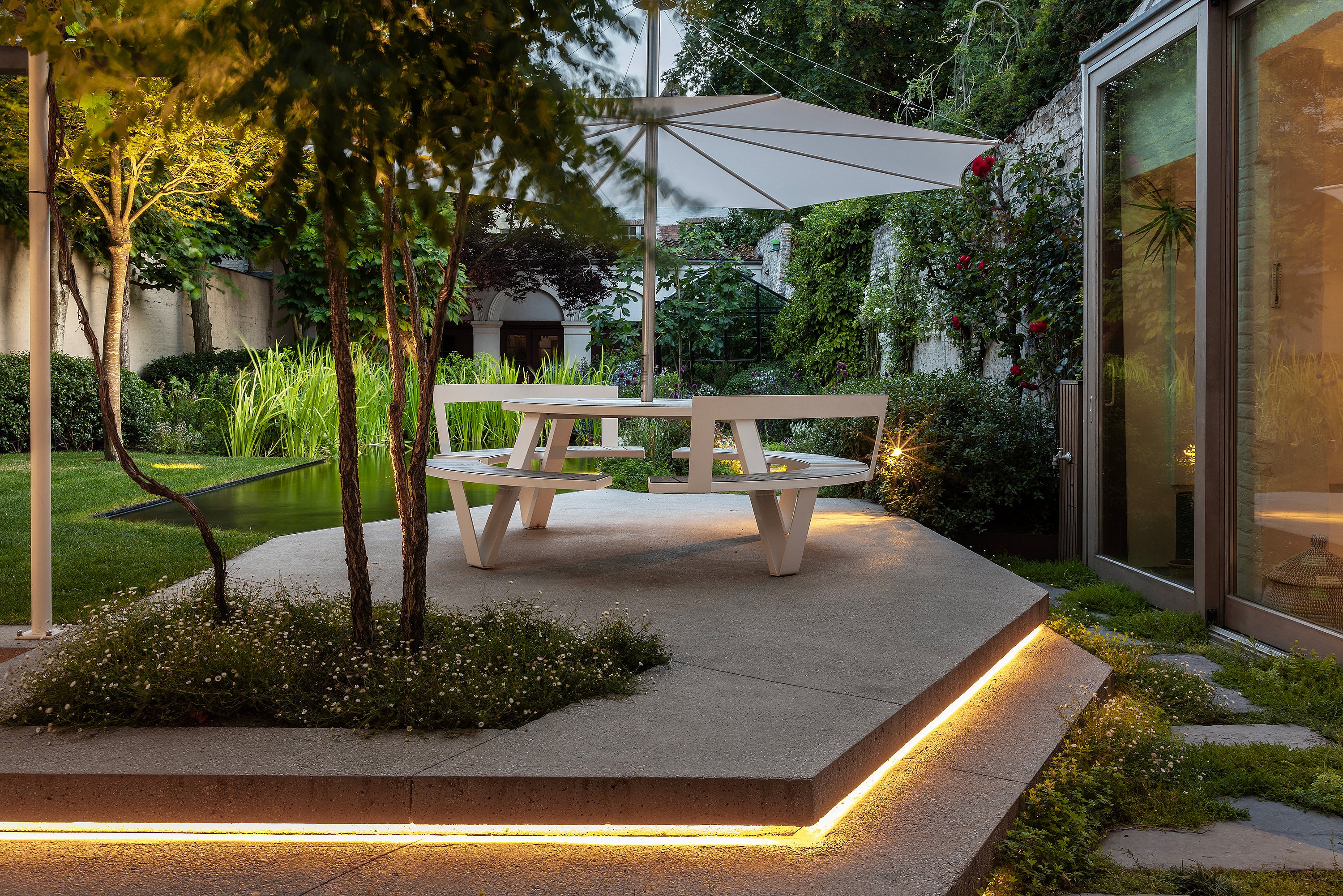 Nahaufnahme des Terrassenrandes, die einen integrierten linearen Lichtstreifen unter der Betonstufe zeigt.