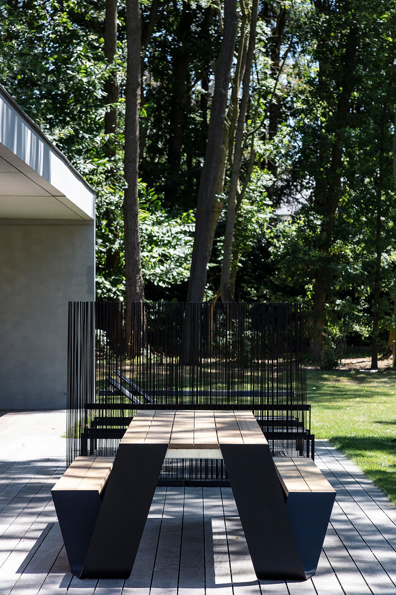 Gros plan sur la table de pique-nique Hopper foncée, avec sa structure en bois et son fin cadre noir sous l'assise.