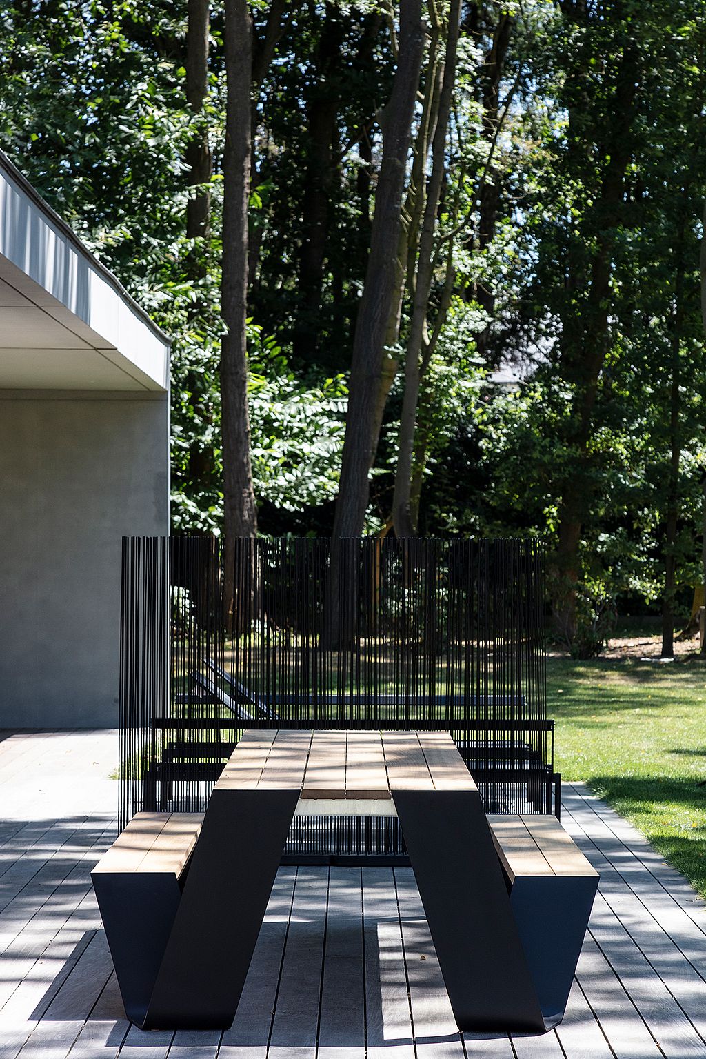Gros plan sur la table de pique-nique Hopper foncée, avec sa structure en bois et son fin cadre noir sous l'assise.