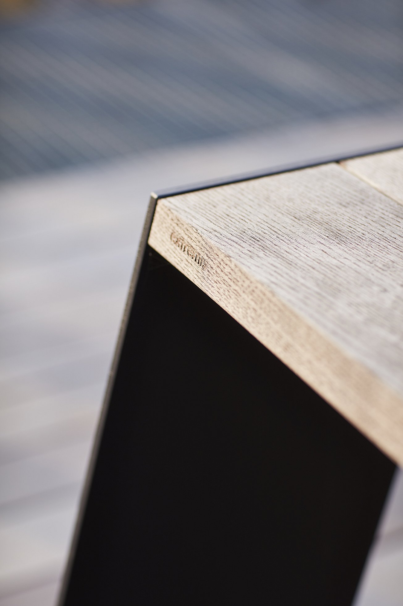 Close-up van de verweerde houten hoek en zwart stalen pootdetail van een Hopper-tafel.