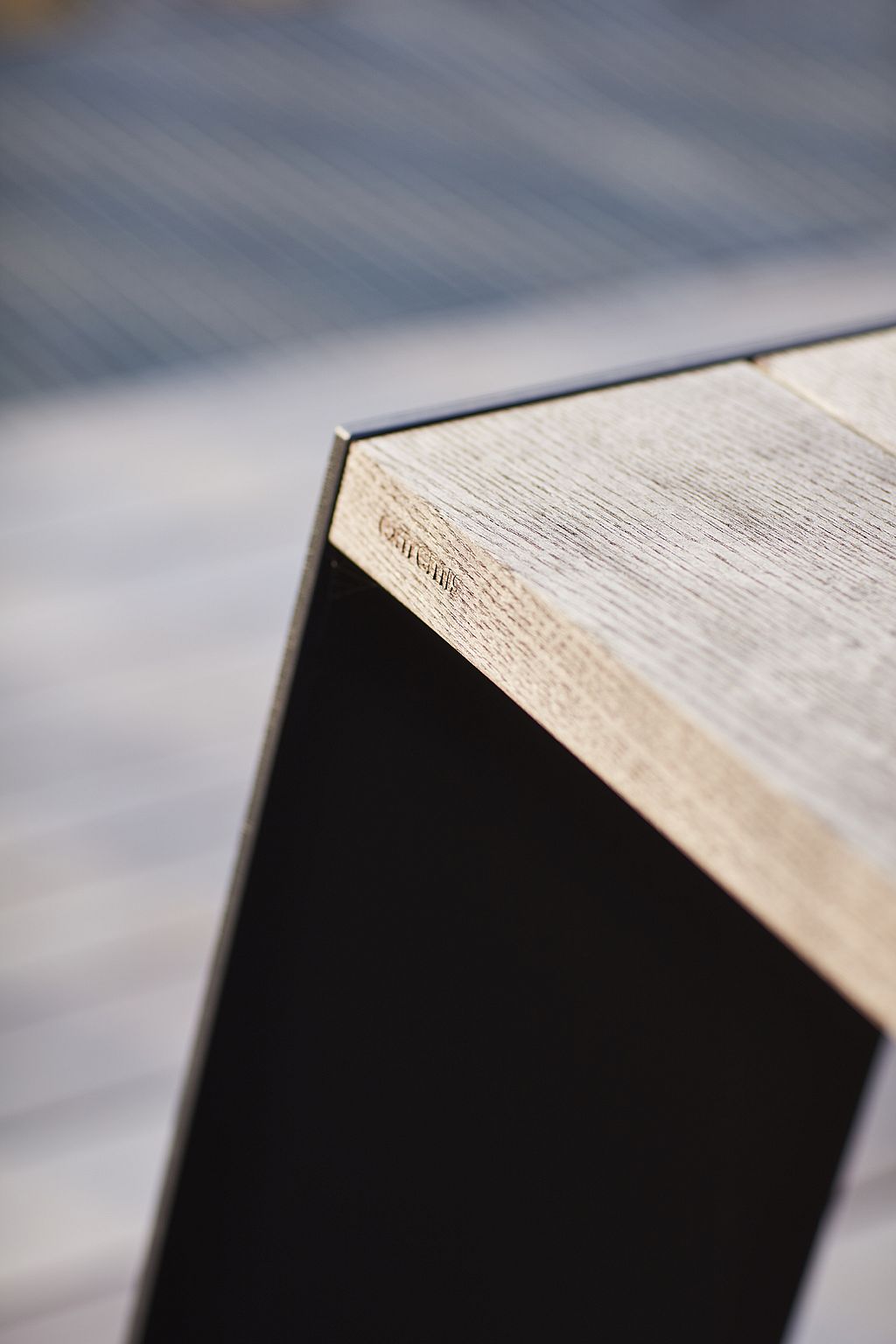 Close-up van de verweerde houten hoek en zwart stalen pootdetail van een Hopper-tafel.