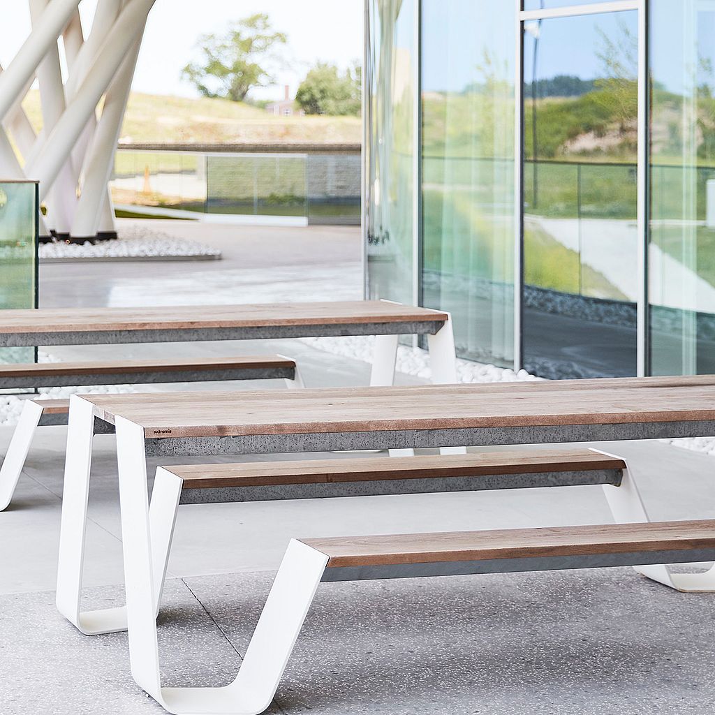 Hopper picnic table with wooden tabletop and benches in a modern outdoor setting