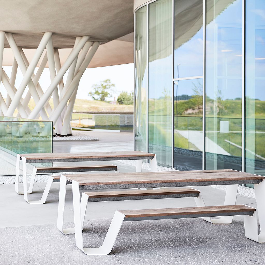 Hopper picnic table with wooden tabletop and benches in a modern outdoor setting