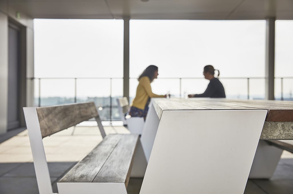 Another exterior of Arhus emphasizing its open public space, with Extremis outdoor seating in the plaza and architectural forms of the modern library building.
