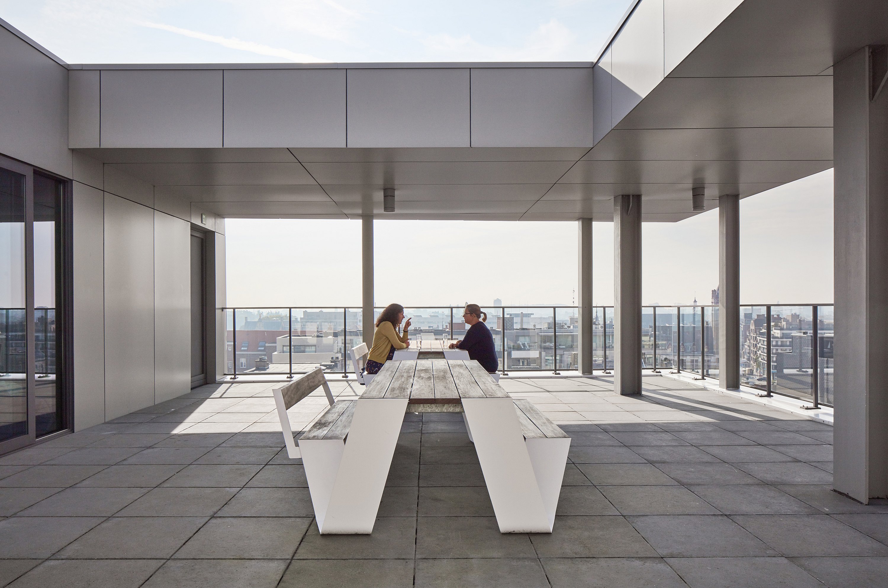 Scene showing more Hopper picnic tables and benches at Arhus library, with visitors enjoying the public space near the building’s entrances.