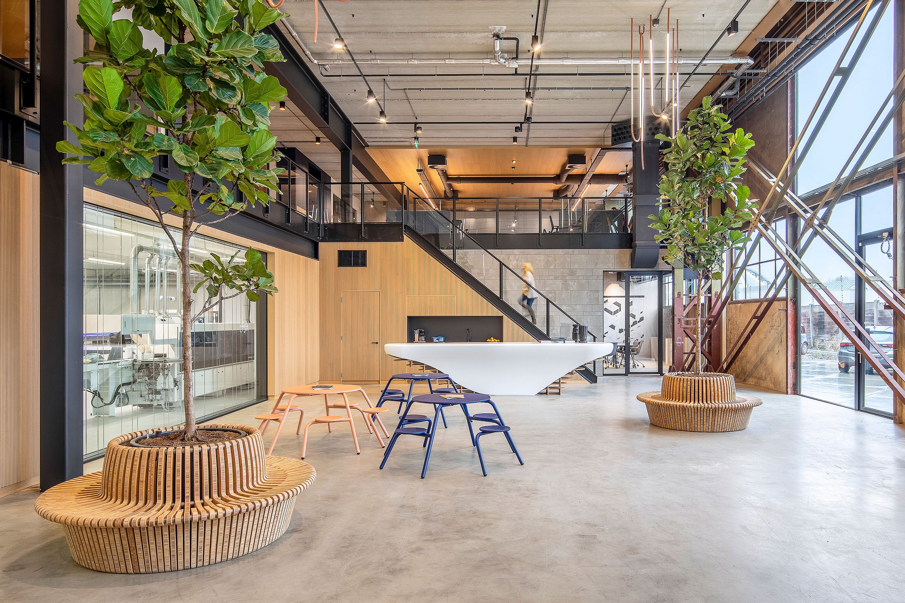 Wide shot of the workshop space showing multiple table groupings and chairs where you can collaborate in a bright, open room.