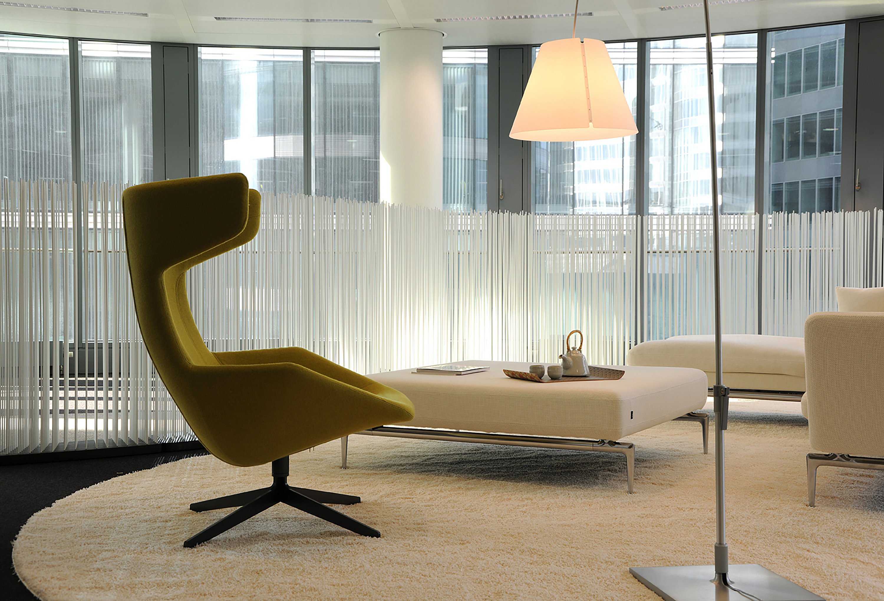   Zeitgenössische Büroräume mit Lounge-Sitzgruppen und Tischen, die durch hohe Extremis Sticks unterteilt sind und so flexible Grenzen zwischen verschiedenen Funktionsbereichen schaffen.