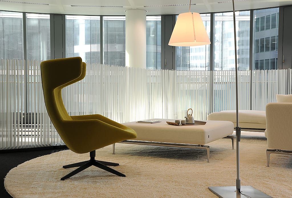 Zeitgenössische Büroräume mit Lounge-Sitzgruppen und Tischen, die durch hohe Extremis Sticks unterteilt sind und so flexible Grenzen zwischen verschiedenen Funktionsbereichen schaffen.
