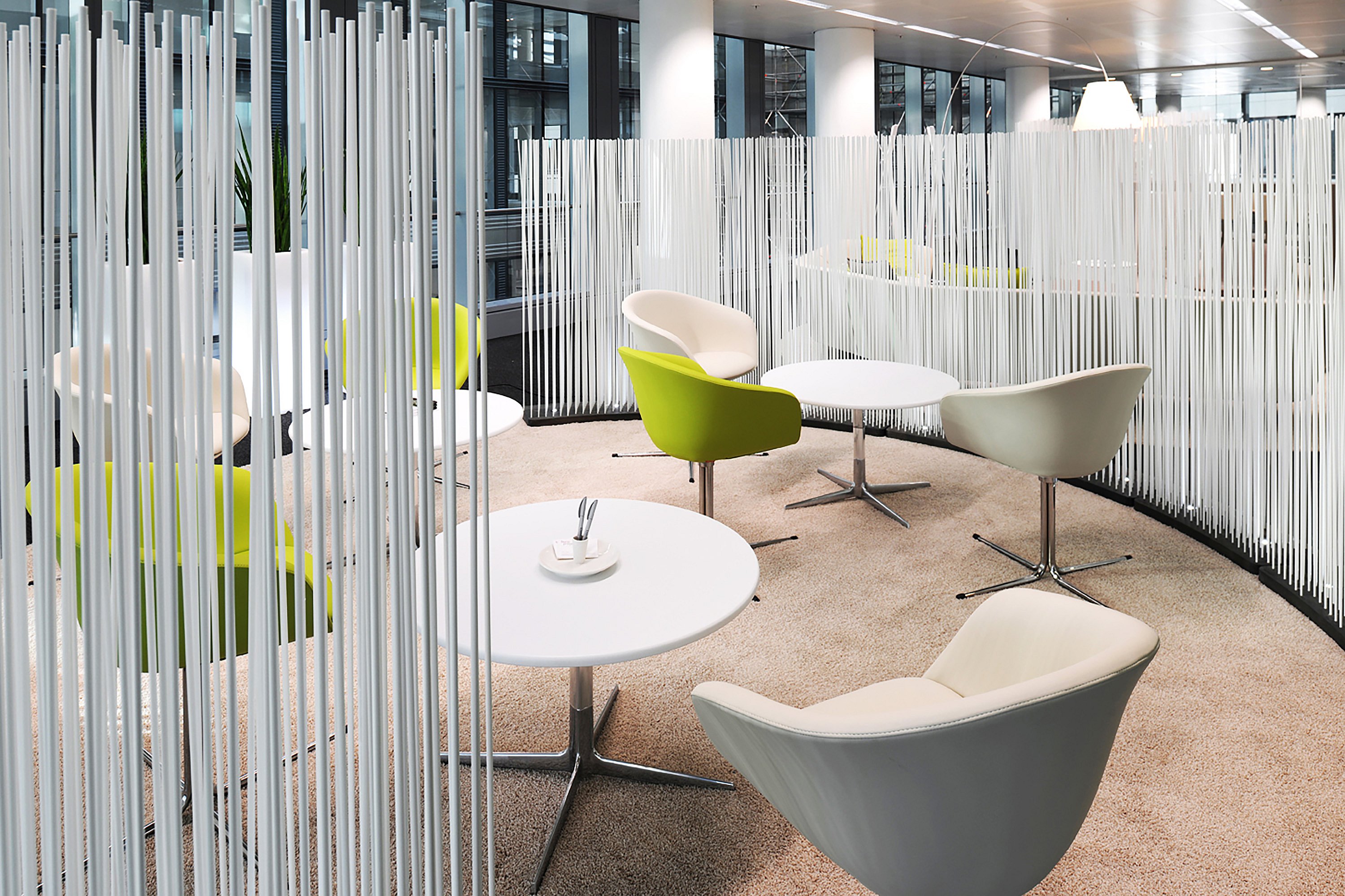 Helle, offene Bürofläche im Covent Garden Business Center in Brüssel mit den Raumteilern Extremis Sticks. Diese vertikalen Stangen trennen Arbeitsbereiche dezent und lassen gleichzeitig Tageslicht durch den Raum fließen.