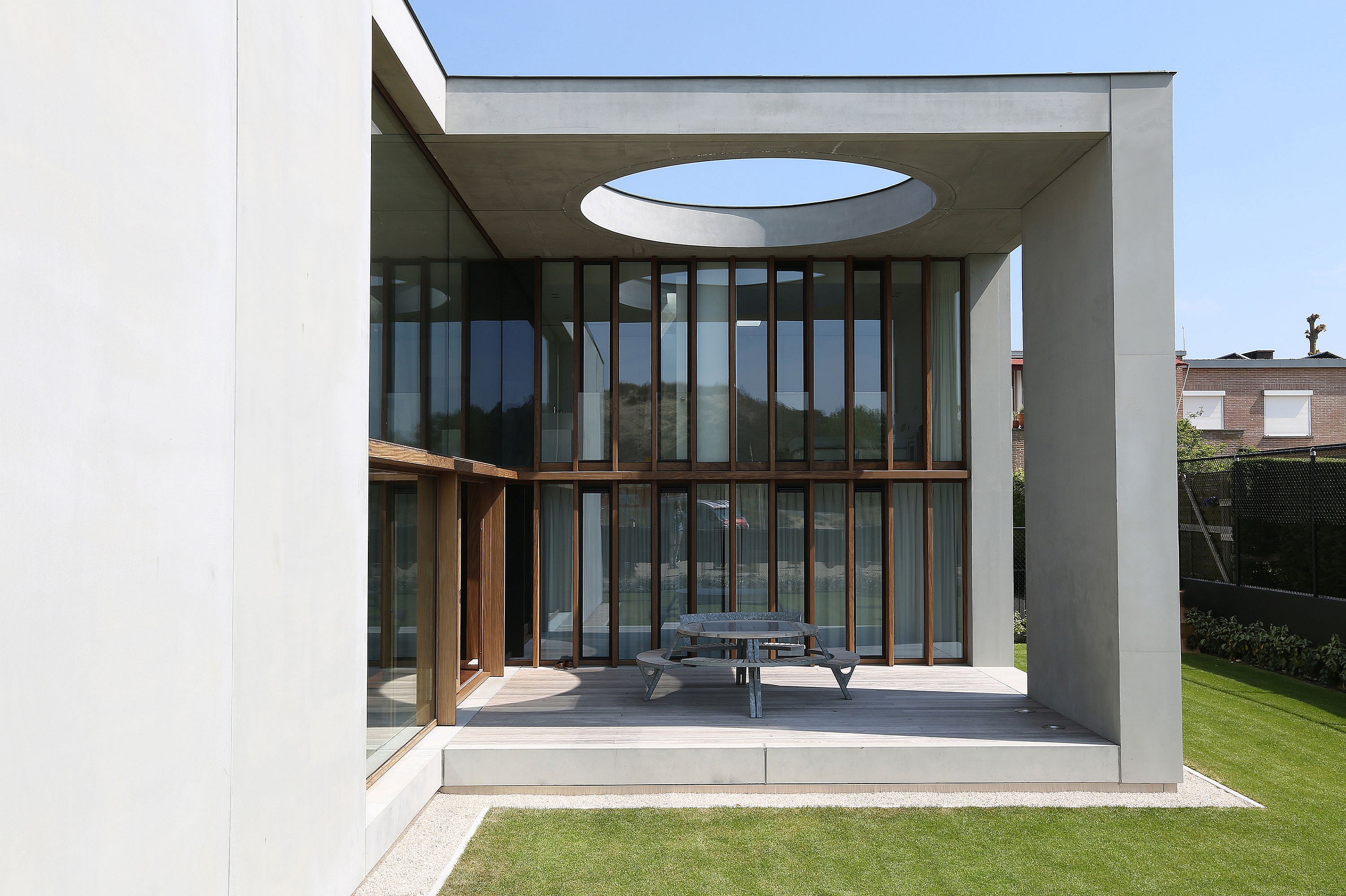 Round Gargantua picnic table with cushions and integrated benches placed on a concrete patio, creating a cozy outdoor family dining area.