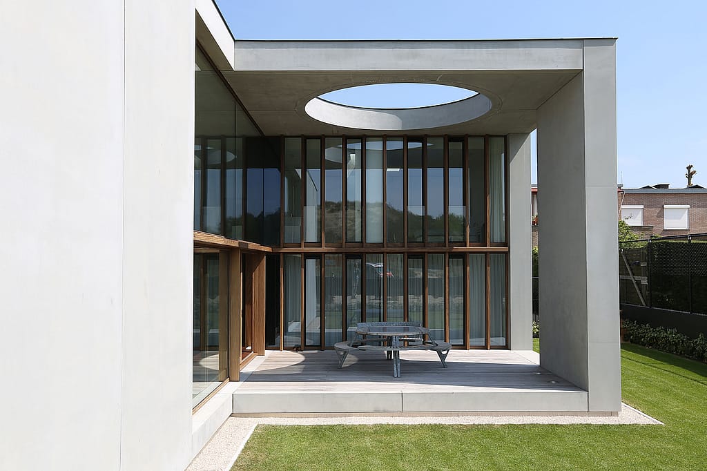 Round Gargantua picnic table with cushions and integrated benches placed on a concrete patio, creating a cozy outdoor family dining area.