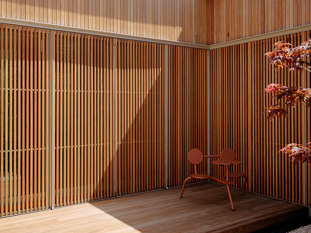 Ein minimalistischer Innenhof mit warmen Holzoberflächen und üppigem Grün, der um einen zentralen Baum herum angelegt wurde und einen ruhigen Rückzugsort im Freien bietet.