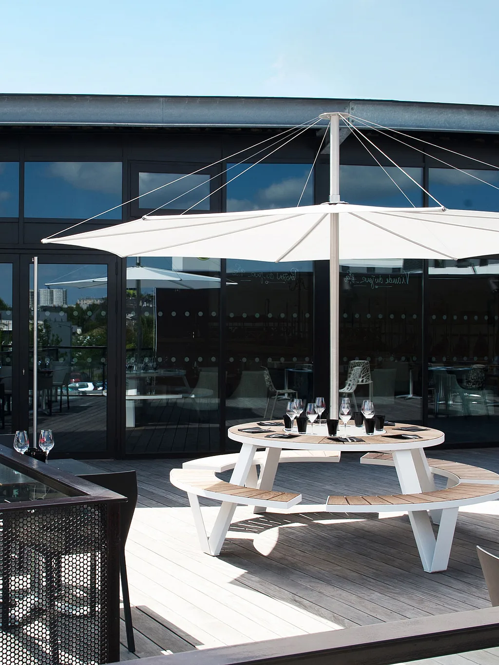 Terrasse extérieure du restaurant Au Comptoir Vénitien à Rennes, aménagée avec des tables de pique-nique rondes Pantagruel et des bancs sous de grands parasols Inumbra.