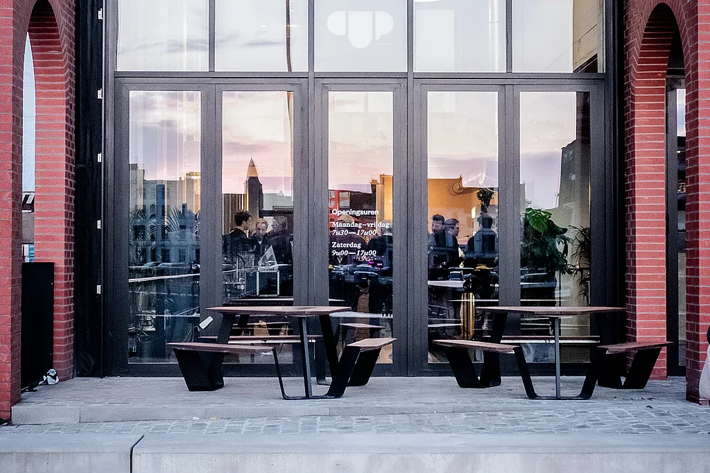 Buitenterras bij CUP Gent met een Anker-tafel, perfect voor gasten die willen genieten van drankjes en snacks in een levendige, sportieve caféomgeving.