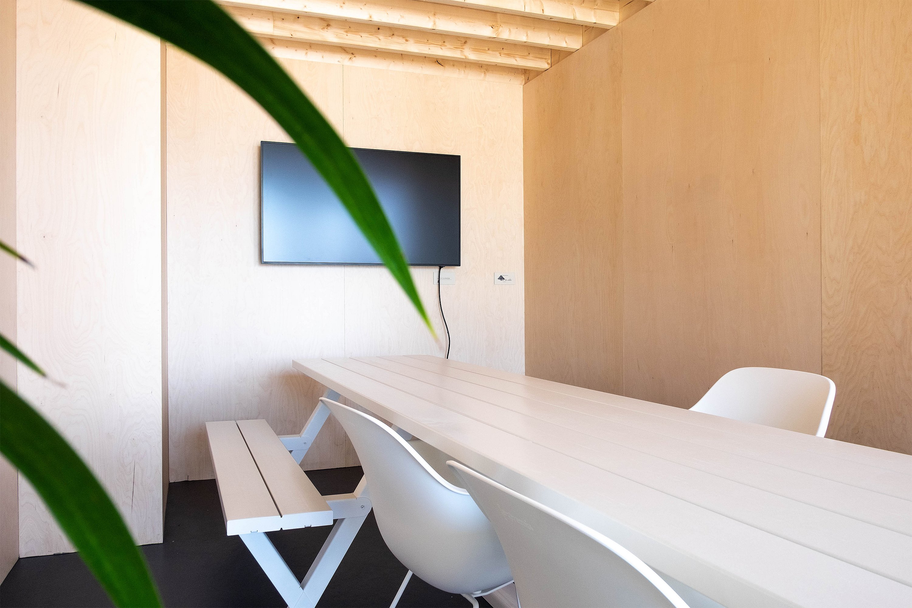 Close-up of the Marina Combo table showing its wooden tabletop and integrated seating in the café terrace setting