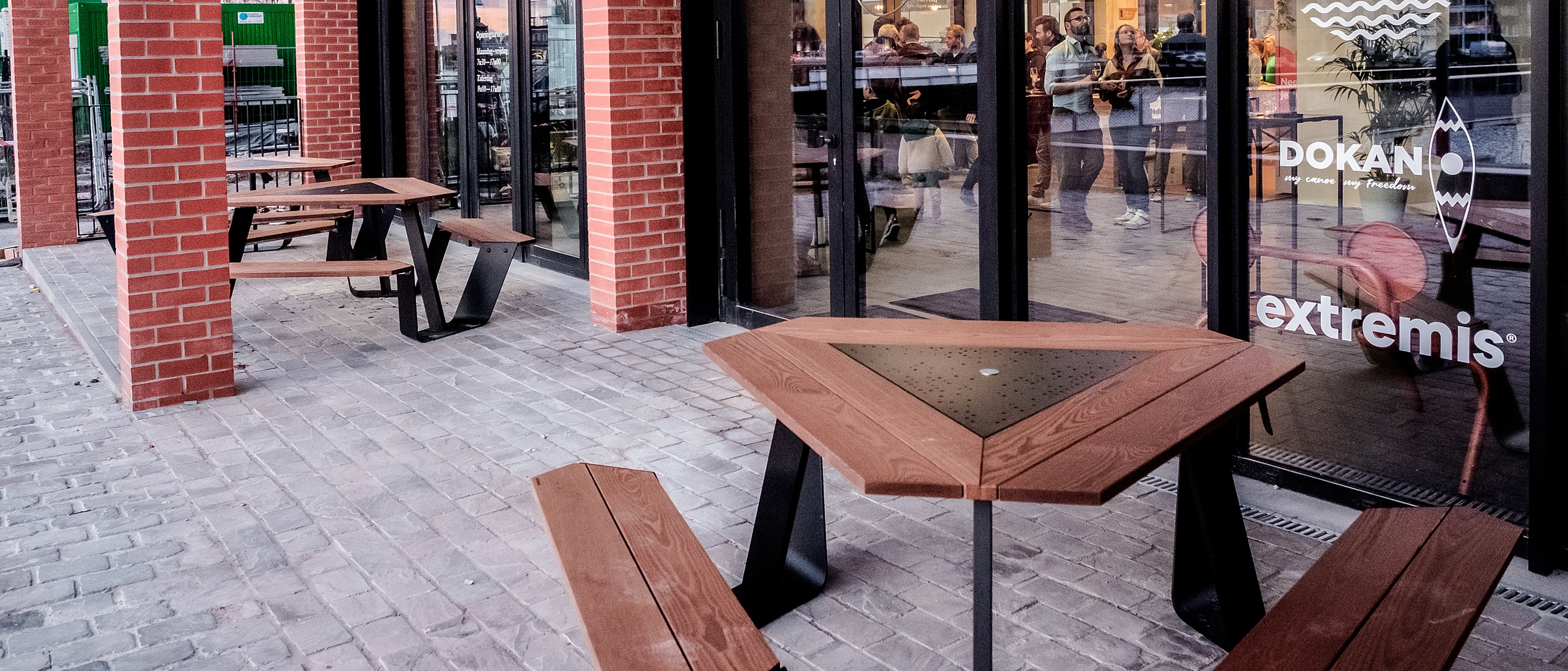 Outdoor seating area at CUP Ghent with multiple Extremis tables creating a welcoming meeting place for athletes and friends.