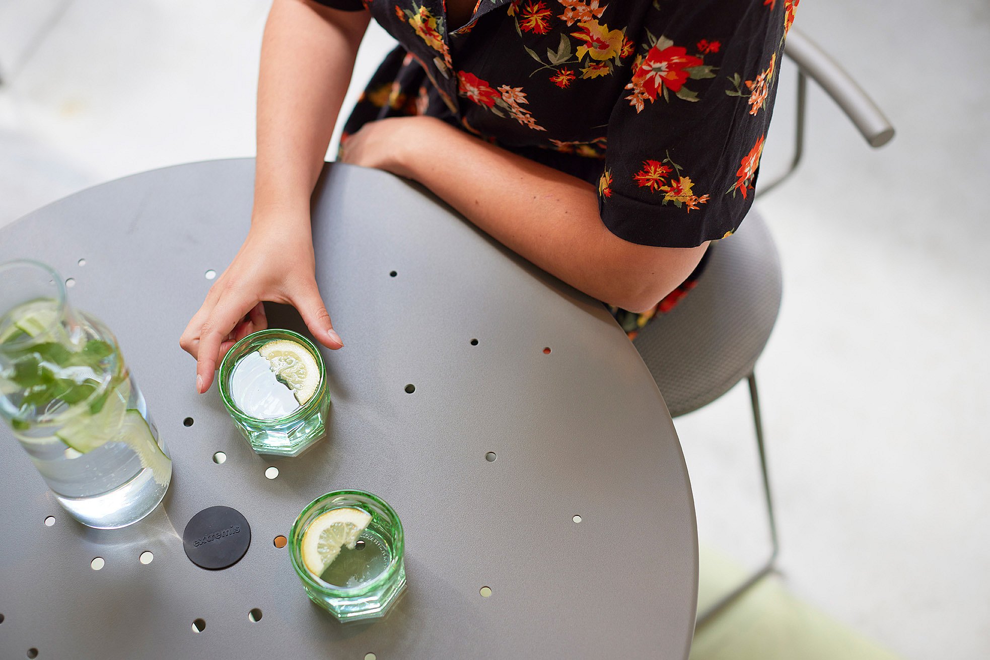   Close-up van een tiki-tafel met tiki-stoelen, waar mensen genieten van een drankje.