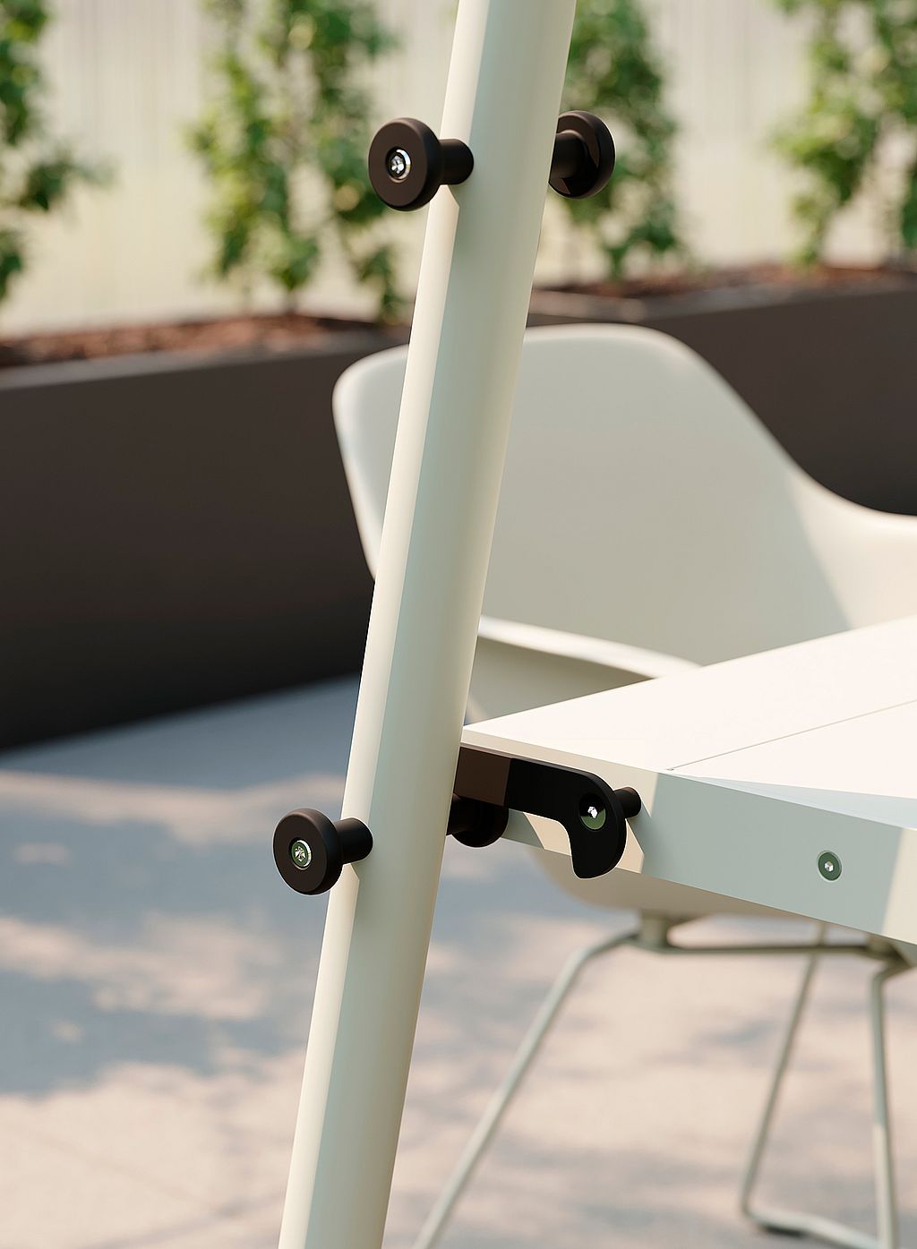 Close-up of the AMAi A-frame and tabletop connection, showing black adjustment knobs and the white metal frame.