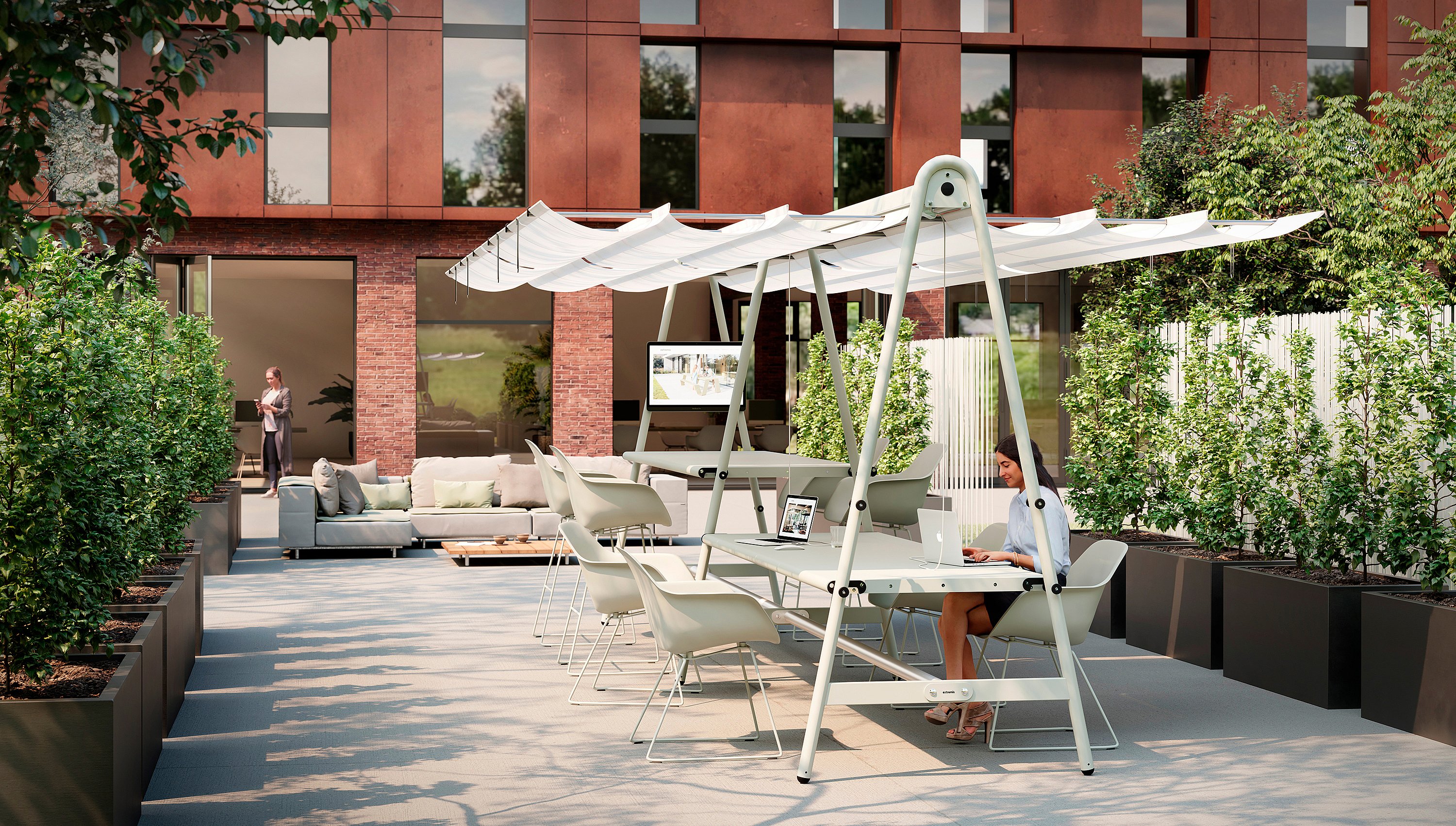 Een buitenkantoor op een terras met een AMAi-tafel en witte Captain's-stoelen onder een geïntegreerd zonnescherm, waar een vrouw op een laptop werkt in een aangelegde binnenplaats naast een modern bakstenen kantoorgebouw.