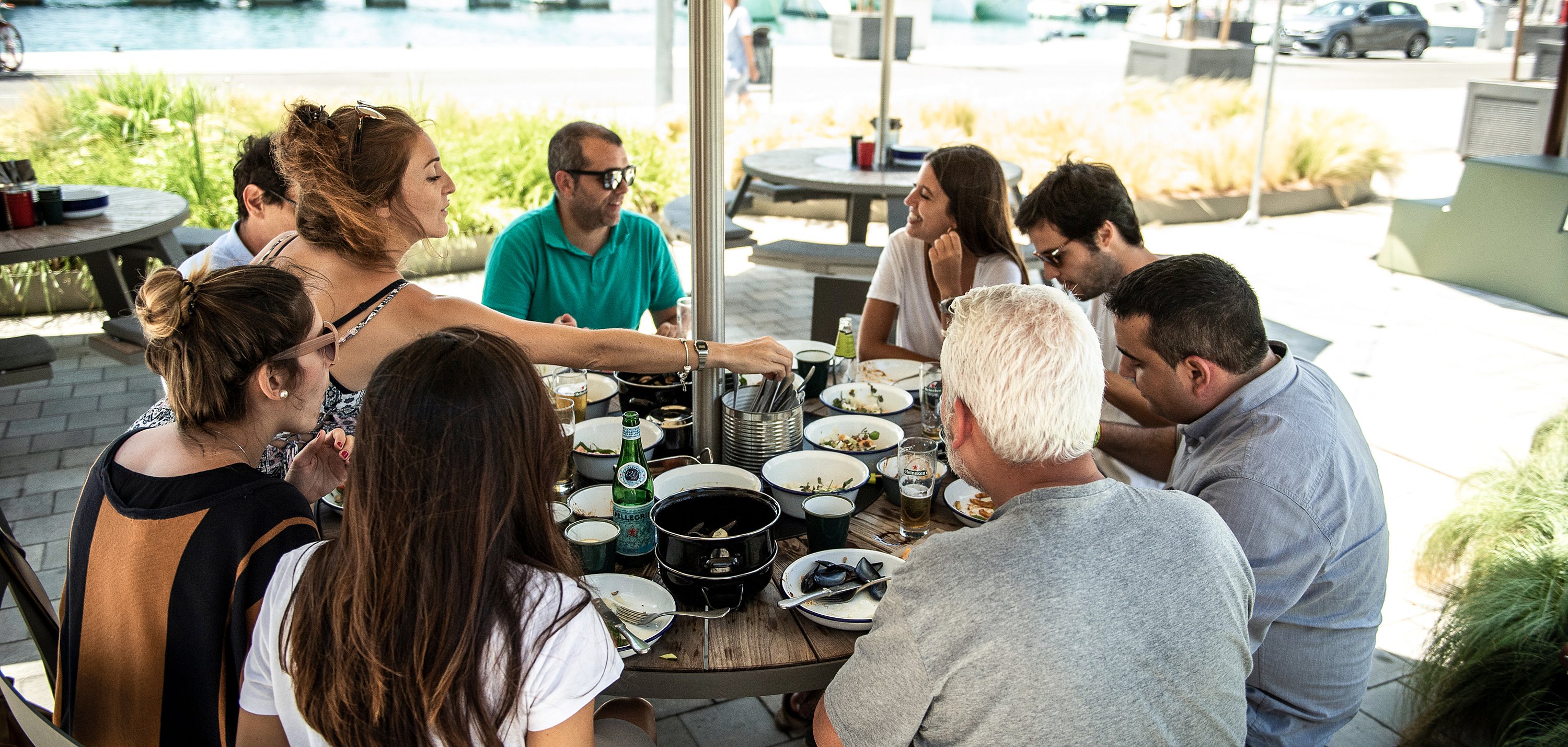 “Outdoor dining terrace with round picnic tables and white parasols, creating a comfortable social setting for meals and conversation.”