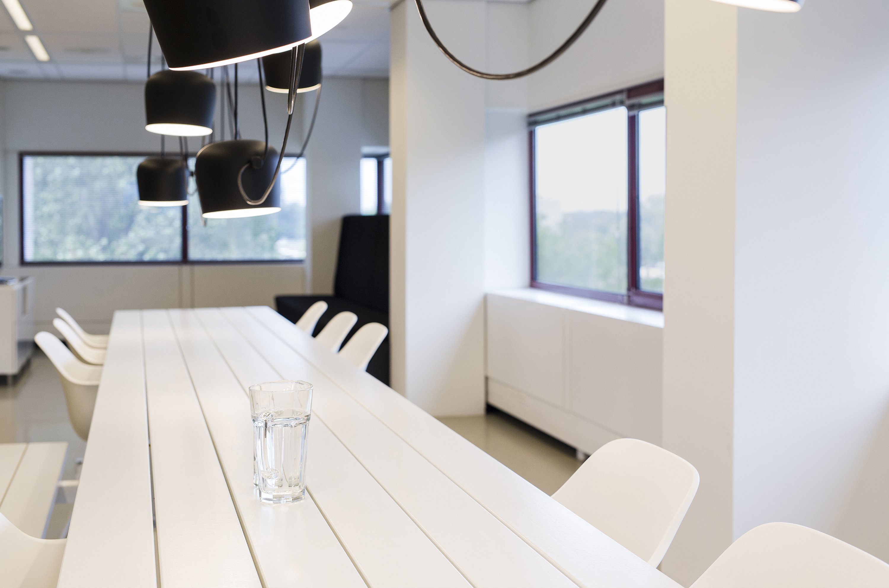 Close-up of the Marina Combo table showing the wooden tabletop and integrated bench seating combined with white Captain’s Chairs.