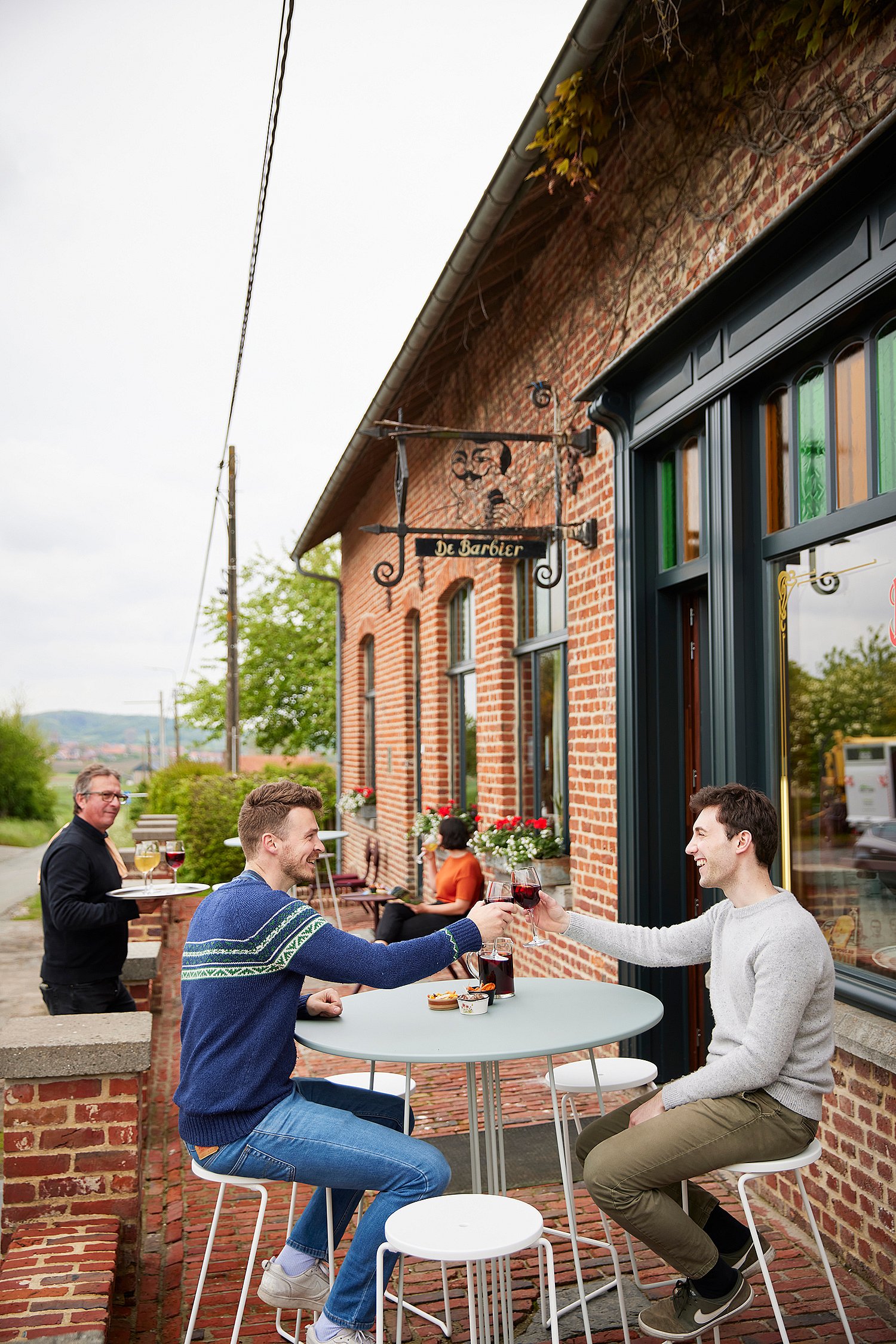 “Cozy terrace with two-person bistro chairs, located on the charming exterior of the café for a pleasant outdoor holiday. ”