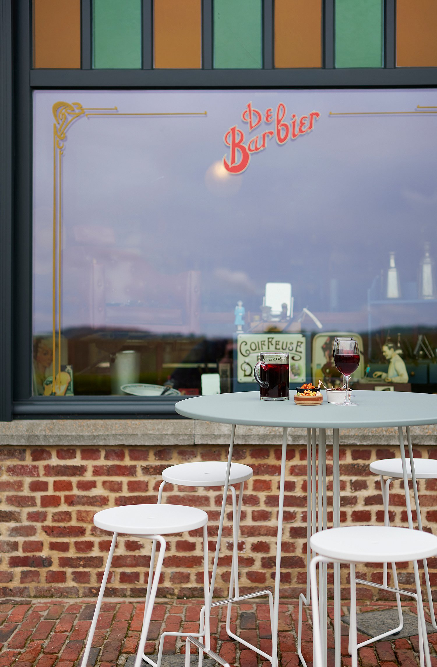 Lightweight tiki table on the terrace, depicted as a flexible piece for temporary café setups that can be easily moved or stored. ”
