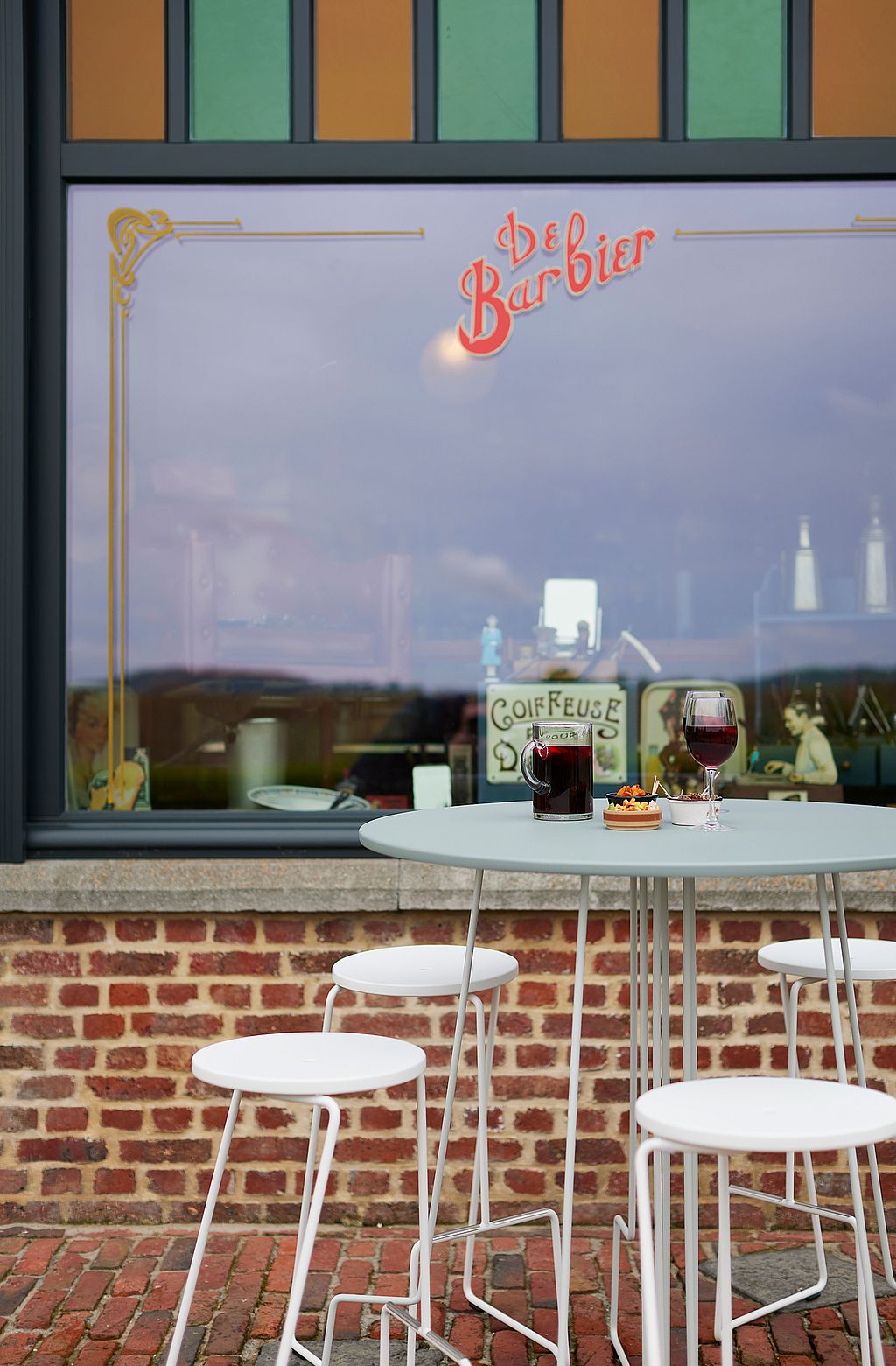 Lightweight tiki table on the terrace, depicted as a flexible piece for temporary café setups that can be easily moved or stored. ”