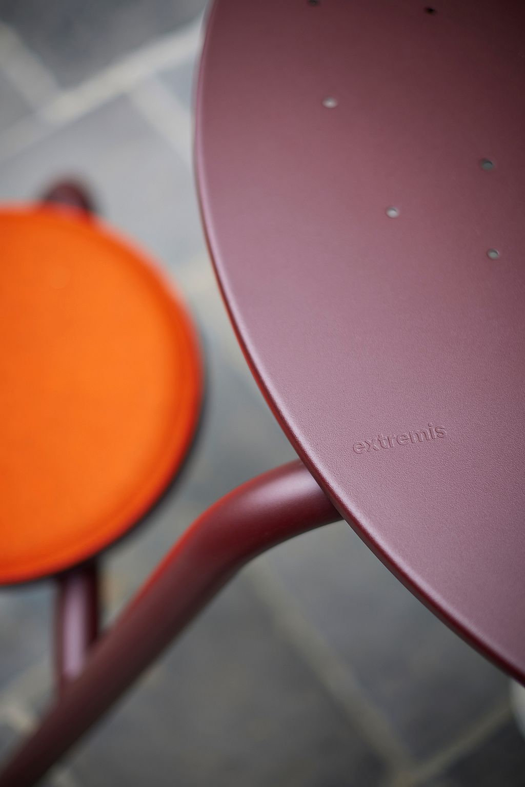 Close-up of a virus table with its playful, round shape and intense color, which stands out from the nostalgic café courtyard.