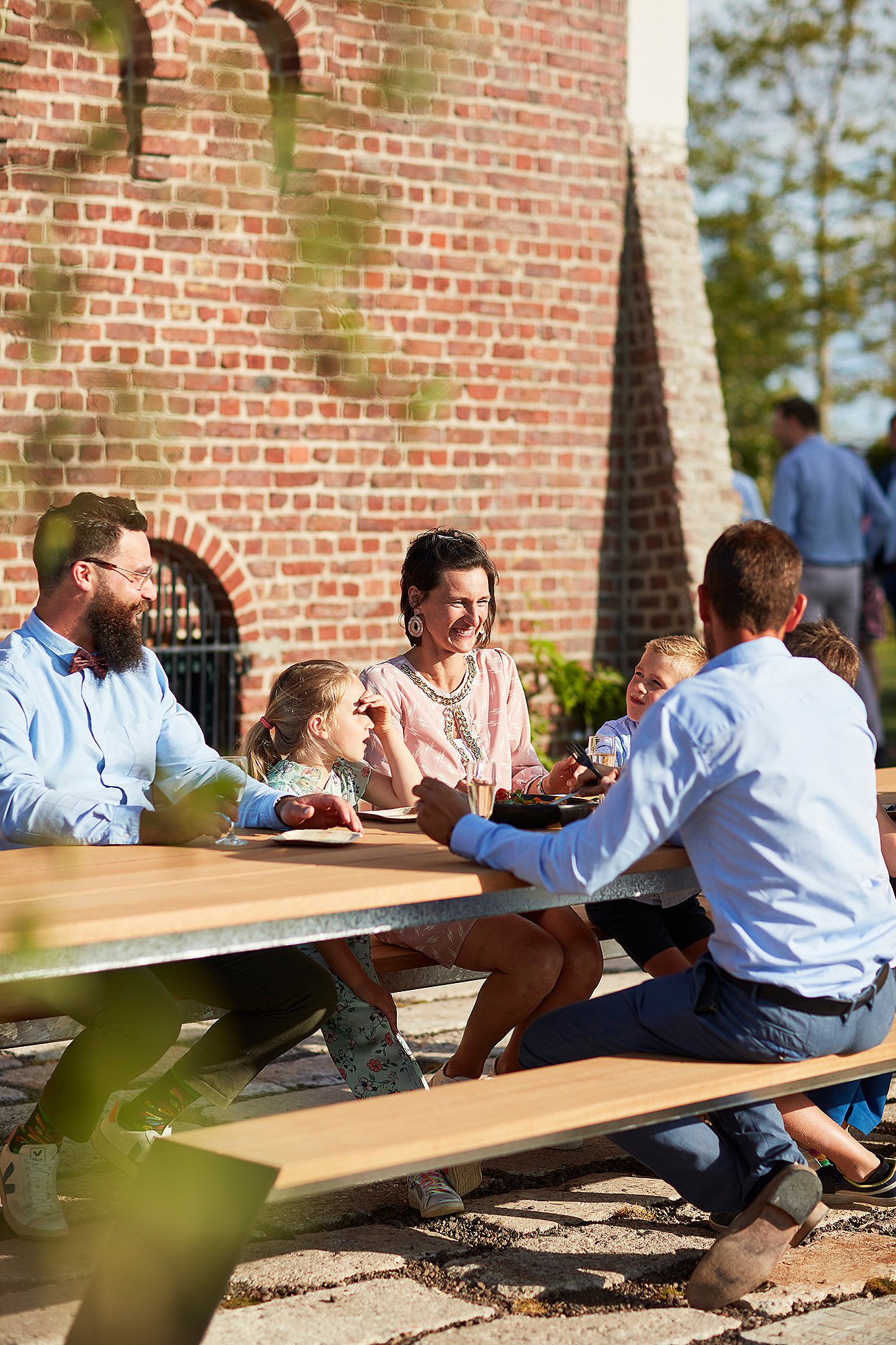 Outdoor family moment around a Hopper table, designed to bring people together in the garden of the renovated farmhouse.