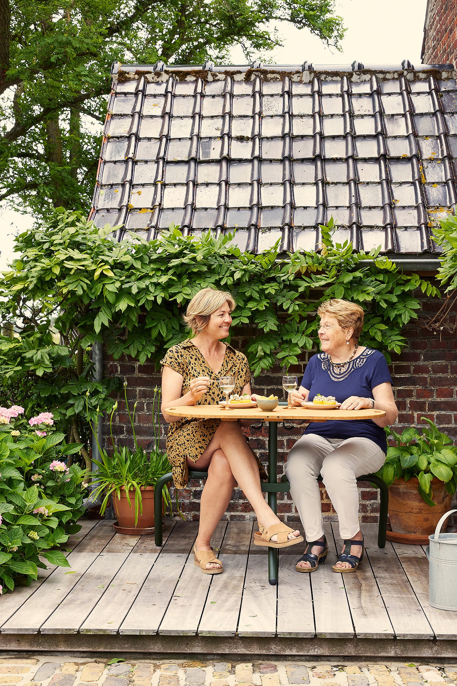 Installation de salle à manger intime Bistroo pour deux, conçue pour des sièges épaule contre épaule sur une terrasse de jardin tranquille.