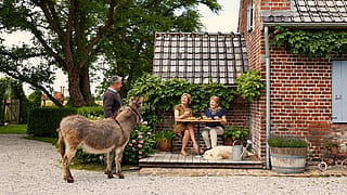 Petite terrasse en bois avec un Bistroo compact à deux places, créant un endroit extérieur confortable pour deux personnes dans un jardin de cottage confortable.
