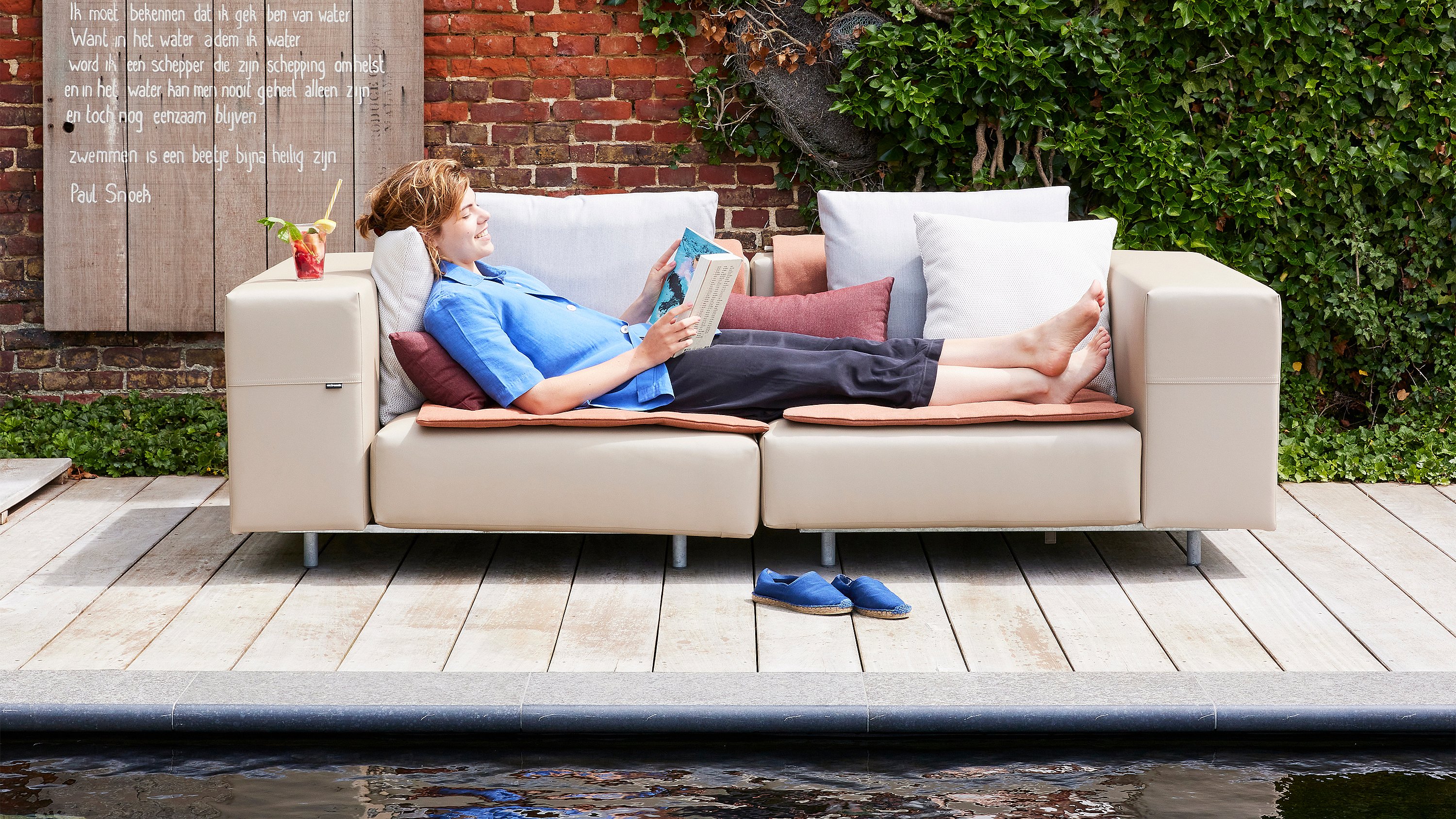 Salon extérieur avec un canapé Walrus arrangé pour une détente confortable dans le jardin de la maison d’hôtes.