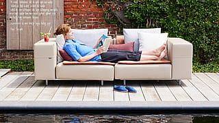 Salon extérieur avec un canapé Walrus arrangé pour une détente confortable dans le jardin de la maison d’hôtes.