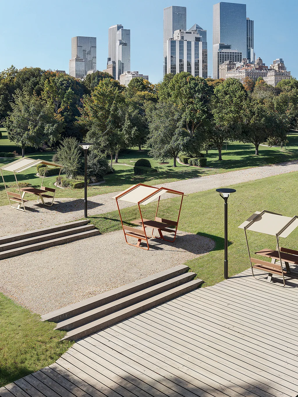 Drei Manille-Picknicktische mit festen Dachschirmen, die über einen angelegten Stadtpark verteilt sind, mit Stufen, Laternenpfählen, einer Holzpromenade über dem Wasser und einer modernen Skyline, die sich hinter den Bäumen erhebt.