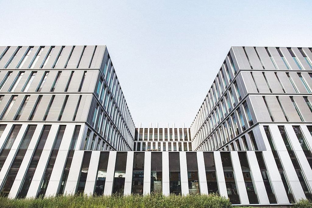 Exterieur van het moderne gebouw van de Universiteit Leiden met een gestreepte witte gevel en smalle verticale ramen.