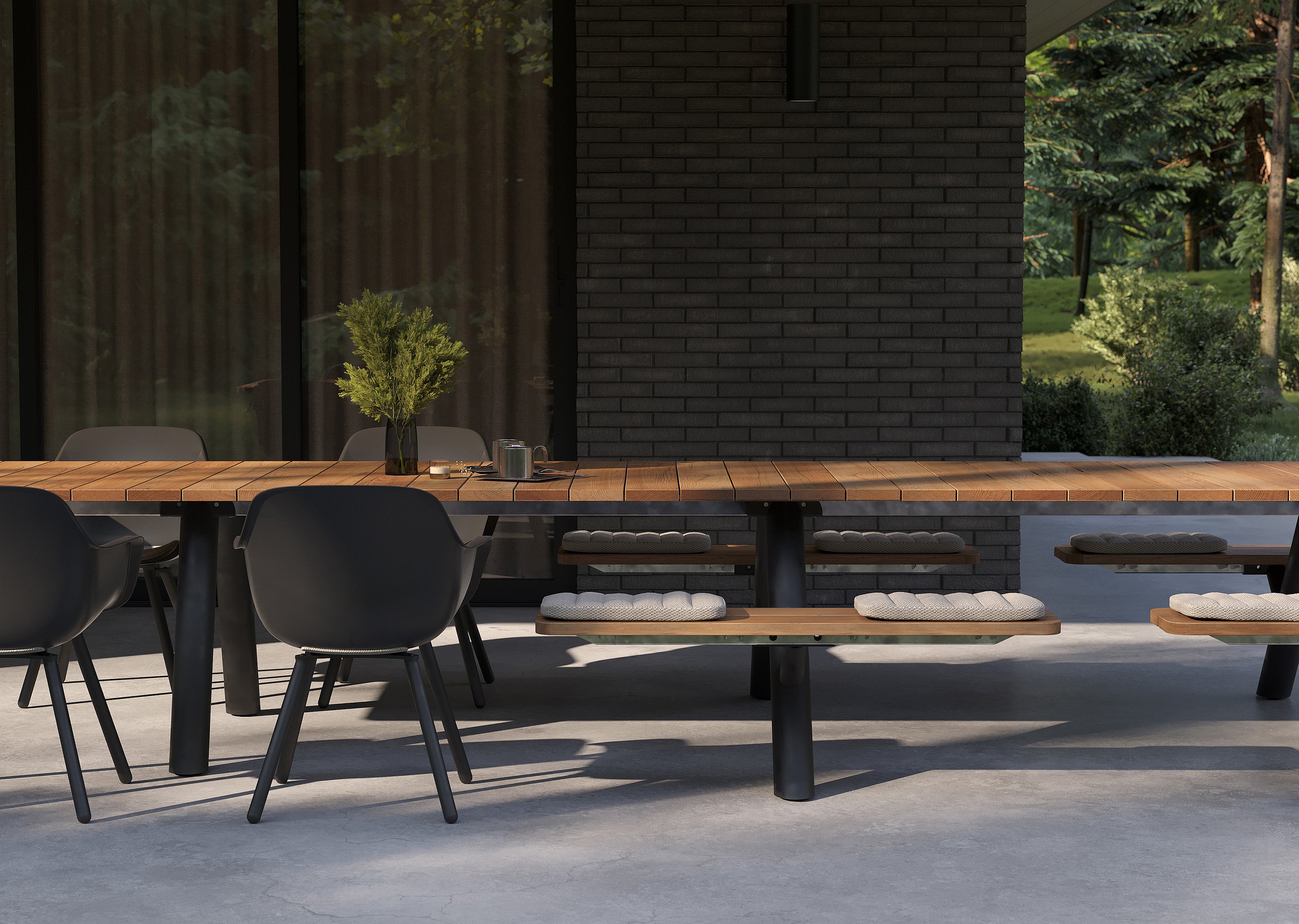 Close view of the wooden Panigiri tabletop, black Captain’s Chairs, and bench cushions on a covered patio in front of a dark brick wall.
