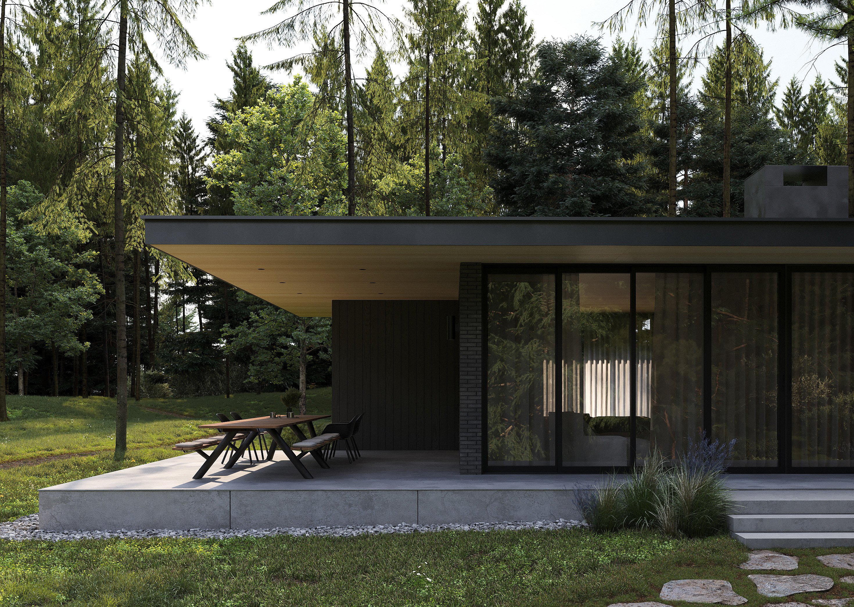 Langer Panigiri-Tisch mit Bänken und schwarzen Kapitänsstühlen auf einer schattigen Betonterrasse neben einem modernen dunklen Bungalow, umgeben von hohen Kiefern.