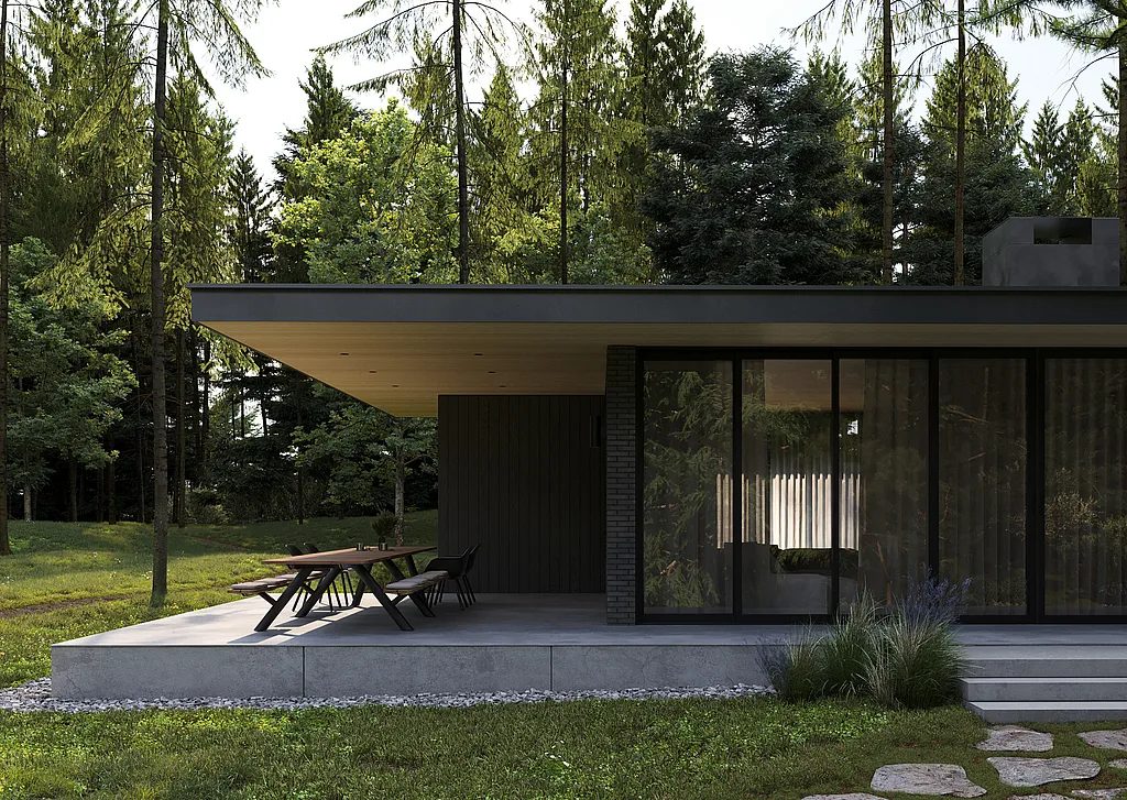 Langer Panigiri-Tisch mit Bänken und schwarzen Kapitänsstühlen auf einer schattigen Betonterrasse neben einem modernen dunklen Bungalow, umgeben von hohen Kiefern.