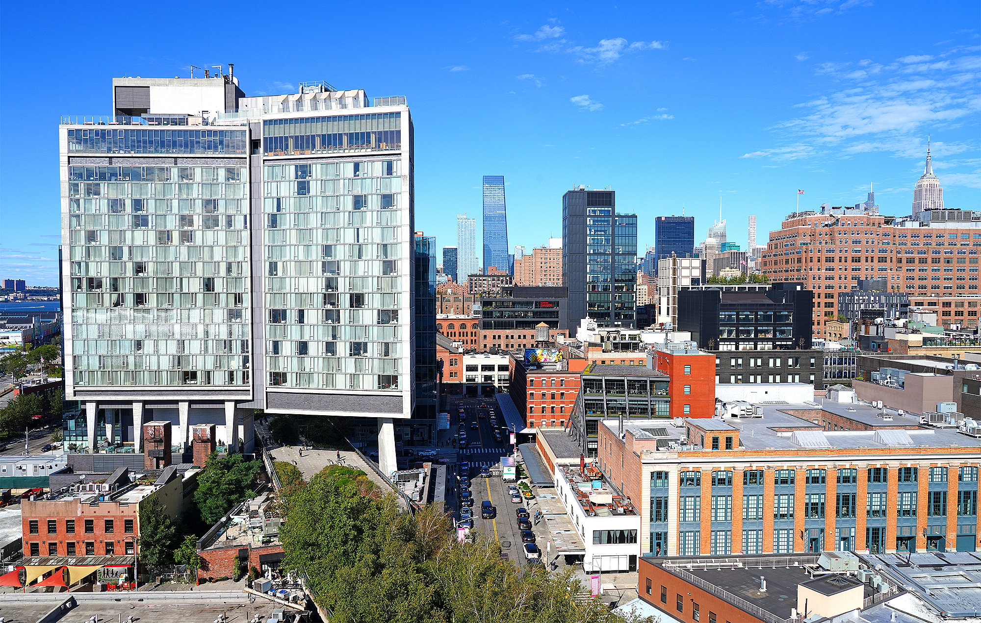 Weite Stadtansicht des Standard Hotels und der umliegenden Dächer Manhattans unter strahlend blauem Himmel.