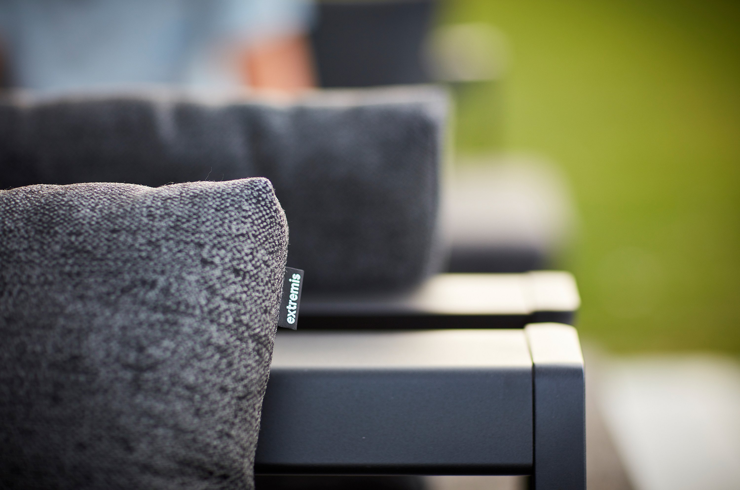   Gros plan sur des coussins gris texturés d'un transat Sol+Luna noir. L'étiquette Extremis est visible sur la couture du coussin.