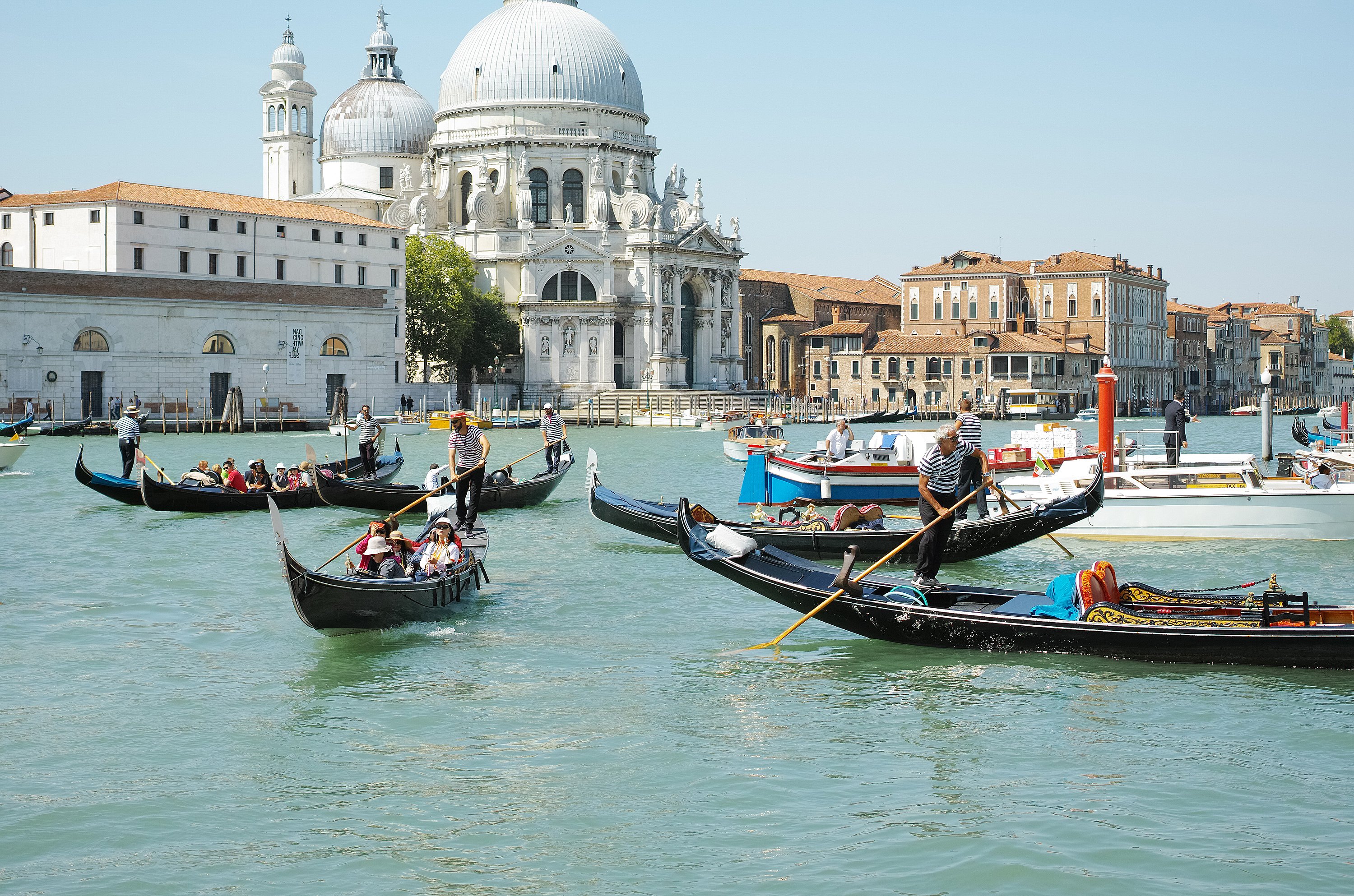 Gondeln überqueren den Canal Grande in Venedig, im Hintergrund erheben sich die Kuppeln von Santa Maria della Salute.