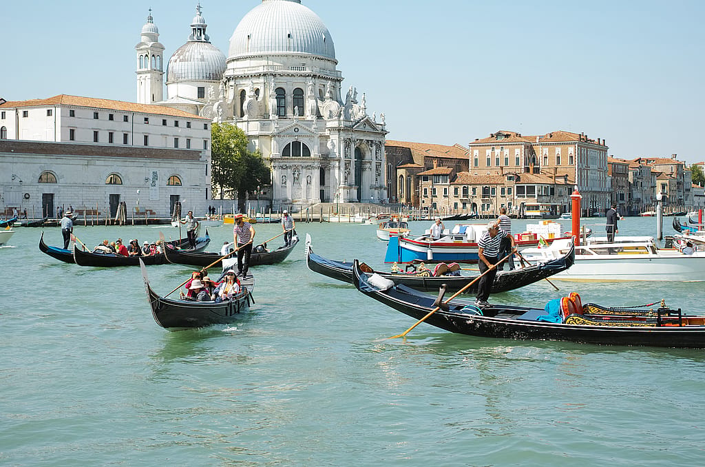 Gondeln überqueren den Canal Grande in Venedig, im Hintergrund erheben sich die Kuppeln von Santa Maria della Salute.