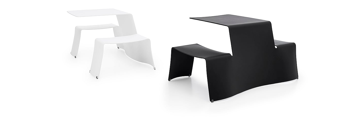   Studiofoto van twee compacte Picnik tafel- en zitcombinaties, een zwarte op de voorgrond en een witte op de achtergrond, afgebeeld tegen een lichtgrijze achtergrond.
