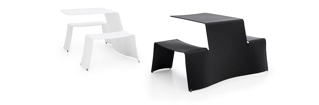 Studiofoto van twee compacte Picnik tafel- en zitcombinaties, een zwarte op de voorgrond en een witte op de achtergrond, afgebeeld tegen een lichtgrijze achtergrond.