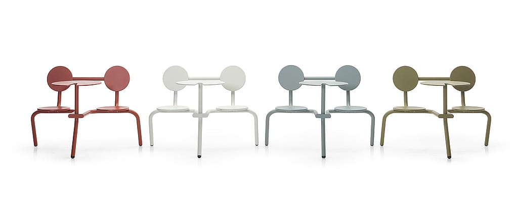 Four powder-coated Bistroo tables are shown in a studio setting, each in a different color: terracotta, white, blue-grey, and olive green.